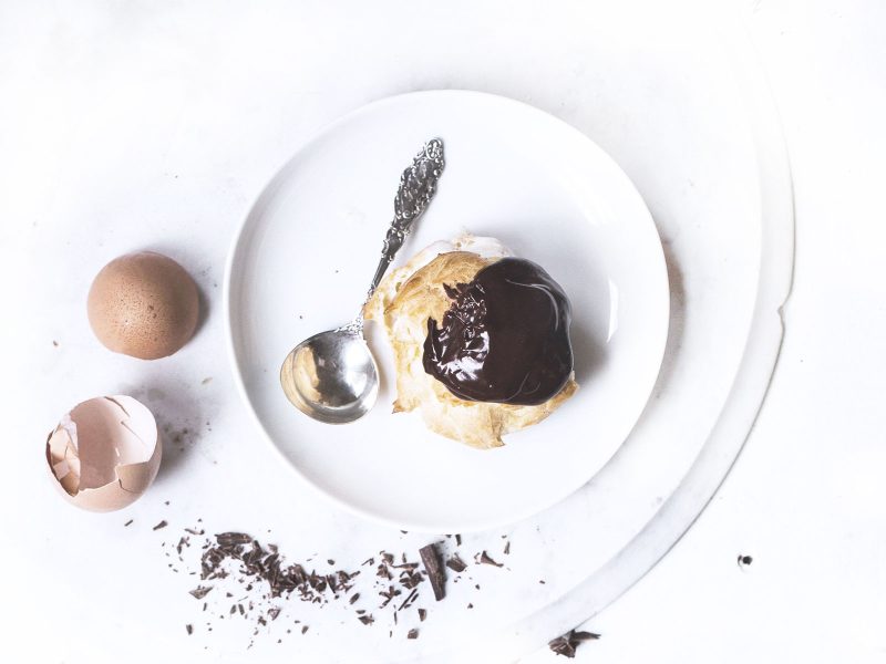 Chocolate profiteroles with vanilla sauce and chocolate slices